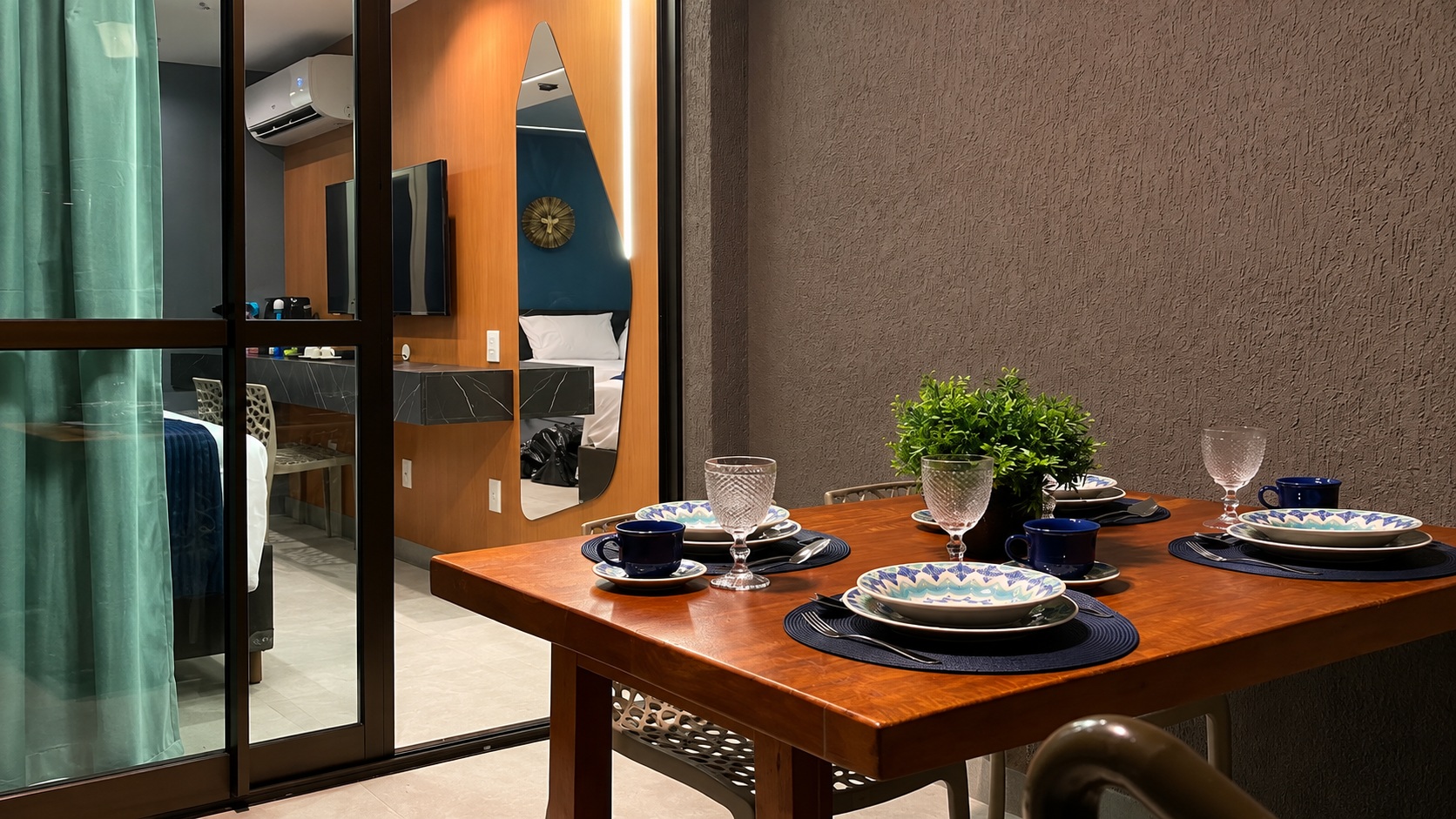 Varanda privativa com mesa posta e vista para o quarto