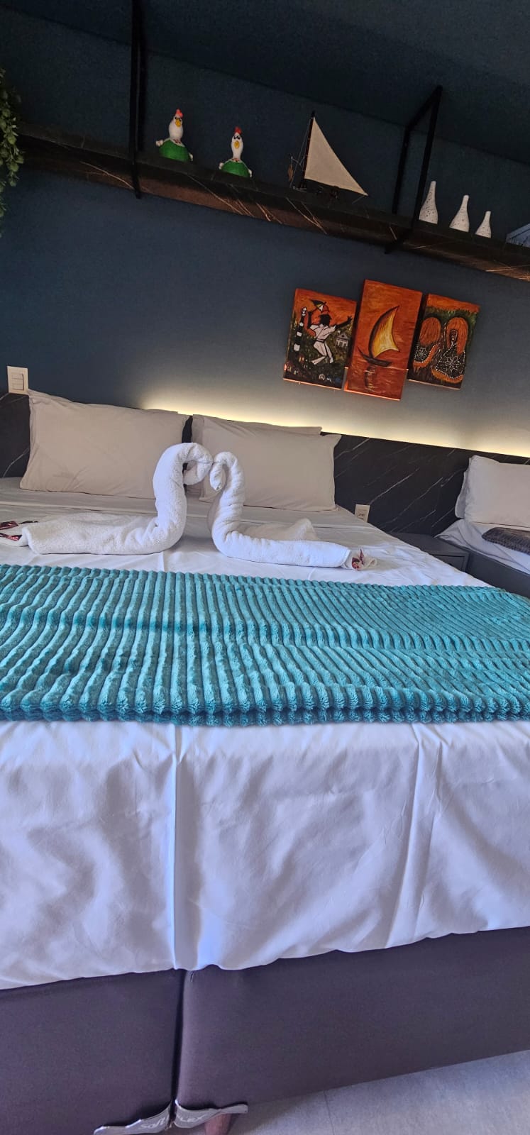 Cama queen preparada com toalhas no quarto do flat